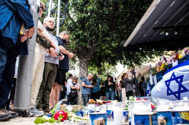Tel Aviv, İsrail - 8 Nisan 2022 Dizengoff Caddesi 'ndeki Ilka Bar' a düzenlenen terörist saldırının ardından insanlar saldırının gerçekleştiği yere mum ve çiçek bırakmak için geliyorlar.