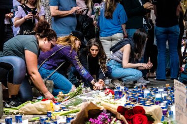 Tel Aviv, İsrail - 8 Nisan 2022 Dizengoff Caddesi 'ndeki Ilka Bar' a düzenlenen terörist saldırının ardından insanlar saldırının gerçekleştiği yere mum ve çiçek bırakmak için geliyorlar.