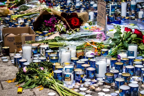 Tel Aviv, İsrail - 8 Nisan 2022 Dizengoff Caddesi 'ndeki Ilka Bar' a düzenlenen terörist saldırının ardından insanlar saldırının gerçekleştiği yere mum ve çiçek bırakmak için geliyorlar.