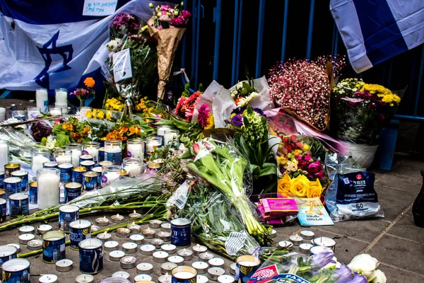 Tel Aviv, İsrail - 8 Nisan 2022 Dizengoff Caddesi 'ndeki Ilka Bar' a düzenlenen terörist saldırının ardından insanlar saldırının gerçekleştiği yere mum ve çiçek bırakmak için geliyorlar.