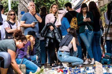 Tel Aviv, İsrail - 8 Nisan 2022 Dizengoff Caddesi 'ndeki Ilka Bar' a düzenlenen terörist saldırının ardından insanlar saldırının gerçekleştiği yere mum ve çiçek bırakmak için geliyorlar.