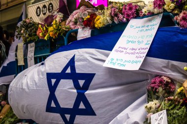 Tel Aviv, İsrail - 8 Nisan 2022 Dizengoff Caddesi 'ndeki Ilka Bar' a düzenlenen terörist saldırının ardından insanlar saldırının gerçekleştiği yere mum ve çiçek bırakmak için geliyorlar.