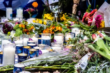 Tel Aviv, İsrail - 8 Nisan 2022 Dizengoff Caddesi 'ndeki Ilka Bar' a düzenlenen terörist saldırının ardından insanlar saldırının gerçekleştiği yere mum ve çiçek bırakmak için geliyorlar.