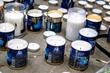 Tel Aviv, İsrail - 8 Nisan 2022 Dizengoff Caddesi 'ndeki Ilka Bar' a düzenlenen terörist saldırının ardından insanlar saldırının gerçekleştiği yere mum ve çiçek bırakmak için geliyorlar.