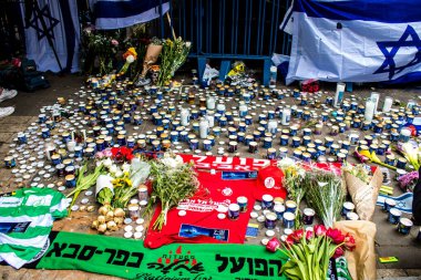 Tel Aviv, İsrail - 8 Nisan 2022 Dizengoff Caddesi 'ndeki Ilka Bar' a düzenlenen terörist saldırının ardından insanlar saldırının gerçekleştiği yere mum ve çiçek bırakmak için geliyorlar.