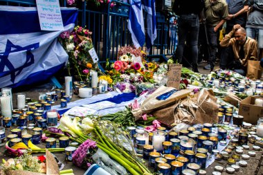 Tel Aviv, İsrail - 8 Nisan 2022 Dizengoff Caddesi 'ndeki Ilka Bar' a düzenlenen terörist saldırının ardından insanlar saldırının gerçekleştiği yere mum ve çiçek bırakmak için geliyorlar.