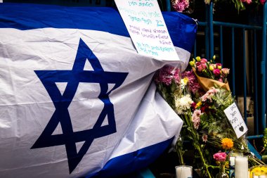 Tel Aviv, İsrail - 8 Nisan 2022 Dizengoff Caddesi 'ndeki Ilka Bar' a düzenlenen terörist saldırının ardından insanlar saldırının gerçekleştiği yere mum ve çiçek bırakmak için geliyorlar.