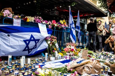 Tel Aviv, İsrail - 8 Nisan 2022 Dizengoff Caddesi 'ndeki Ilka Bar' a düzenlenen terörist saldırının ardından insanlar saldırının gerçekleştiği yere mum ve çiçek bırakmak için geliyorlar.