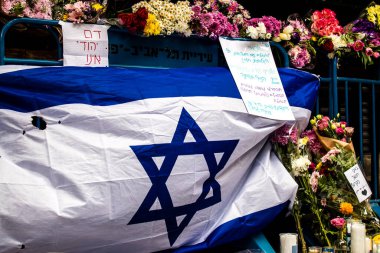 Tel Aviv, İsrail - 8 Nisan 2022 Dizengoff Caddesi 'ndeki Ilka Bar' a düzenlenen terörist saldırının ardından insanlar saldırının gerçekleştiği yere mum ve çiçek bırakmak için geliyorlar.