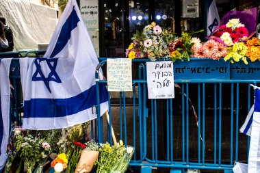 Tel Aviv, İsrail - 8 Nisan 2022 Dizengoff Caddesi 'ndeki Ilka Bar' a düzenlenen terörist saldırının ardından insanlar saldırının gerçekleştiği yere mum ve çiçek bırakmak için geliyorlar.