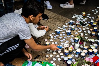 Tel Aviv, İsrail - 8 Nisan 2022 Dizengoff Caddesi 'ndeki Ilka Bar' a düzenlenen terörist saldırının ardından insanlar saldırının gerçekleştiği yere mum ve çiçek bırakmak için geliyorlar.