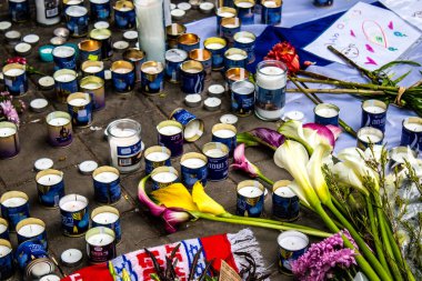 Tel Aviv, İsrail - 8 Nisan 2022 Dizengoff Caddesi 'ndeki Ilka Bar' a düzenlenen terörist saldırının ardından insanlar saldırının gerçekleştiği yere mum ve çiçek bırakmak için geliyorlar.
