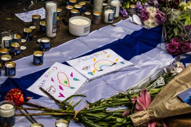 Tel Aviv, İsrail - 8 Nisan 2022 Dizengoff Caddesi 'ndeki Ilka Bar' a düzenlenen terörist saldırının ardından insanlar saldırının gerçekleştiği yere mum ve çiçek bırakmak için geliyorlar.