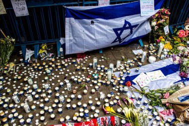 Tel Aviv, İsrail - 8 Nisan 2022 Dizengoff Caddesi 'ndeki Ilka Bar' a düzenlenen terörist saldırının ardından insanlar saldırının gerçekleştiği yere mum ve çiçek bırakmak için geliyorlar.