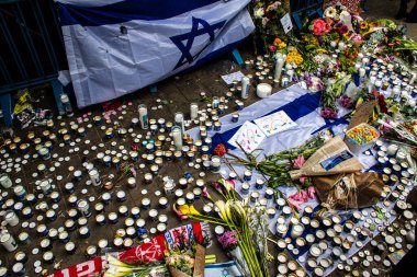 Tel Aviv, İsrail - 8 Nisan 2022 Dizengoff Caddesi 'ndeki Ilka Bar' a düzenlenen terörist saldırının ardından insanlar saldırının gerçekleştiği yere mum ve çiçek bırakmak için geliyorlar.