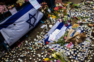 Tel Aviv, İsrail - 8 Nisan 2022 Dizengoff Caddesi 'ndeki Ilka Bar' a düzenlenen terörist saldırının ardından insanlar saldırının gerçekleştiği yere mum ve çiçek bırakmak için geliyorlar.
