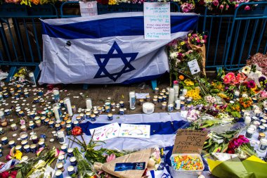 Tel Aviv, İsrail - 8 Nisan 2022 Dizengoff Caddesi 'ndeki Ilka Bar' a düzenlenen terörist saldırının ardından insanlar saldırının gerçekleştiği yere mum ve çiçek bırakmak için geliyorlar.
