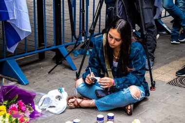 Tel Aviv, İsrail - 8 Nisan 2022 Dizengoff Caddesi 'ndeki Ilka Bar' a düzenlenen terörist saldırının ardından insanlar saldırının gerçekleştiği yere mum ve çiçek bırakmak için geliyorlar.