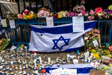 Tel Aviv, İsrail - 8 Nisan 2022 Dizengoff Caddesi 'ndeki Ilka Bar' a düzenlenen terörist saldırının ardından insanlar saldırının gerçekleştiği yere mum ve çiçek bırakmak için geliyorlar.