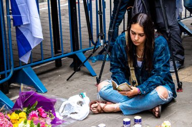 Tel Aviv, İsrail - 8 Nisan 2022 Dizengoff Caddesi 'ndeki Ilka Bar' a düzenlenen terörist saldırının ardından insanlar saldırının gerçekleştiği yere mum ve çiçek bırakmak için geliyorlar.