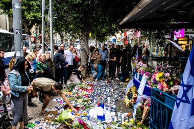 Tel Aviv, İsrail - 8 Nisan 2022 Dizengoff Caddesi 'ndeki Ilka Bar' a düzenlenen terörist saldırının ardından insanlar saldırının gerçekleştiği yere mum ve çiçek bırakmak için geliyorlar.