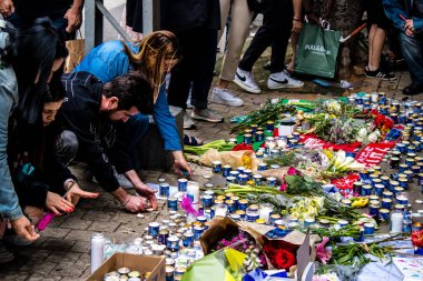 Tel Aviv, İsrail - 8 Nisan 2022 Dizengoff Caddesi 'ndeki Ilka Bar' a düzenlenen terörist saldırının ardından insanlar saldırının gerçekleştiği yere mum ve çiçek bırakmak için geliyorlar.
