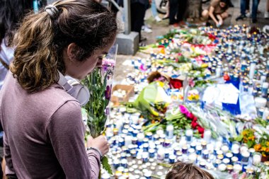 Tel Aviv, İsrail - 8 Nisan 2022 Dizengoff Caddesi 'ndeki Ilka Bar' a düzenlenen terörist saldırının ardından insanlar saldırının gerçekleştiği yere mum ve çiçek bırakmak için geliyorlar.