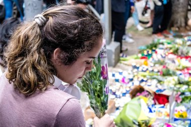 Tel Aviv, İsrail - 8 Nisan 2022 Dizengoff Caddesi 'ndeki Ilka Bar' a düzenlenen terörist saldırının ardından insanlar saldırının gerçekleştiği yere mum ve çiçek bırakmak için geliyorlar.