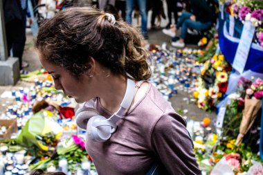 Tel Aviv, İsrail - 8 Nisan 2022 Dizengoff Caddesi 'ndeki Ilka Bar' a düzenlenen terörist saldırının ardından insanlar saldırının gerçekleştiği yere mum ve çiçek bırakmak için geliyorlar.