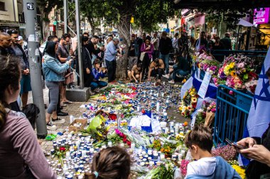 Tel Aviv, İsrail - 8 Nisan 2022 Dizengoff Caddesi 'ndeki Ilka Bar' a düzenlenen terörist saldırının ardından insanlar saldırının gerçekleştiği yere mum ve çiçek bırakmak için geliyorlar.