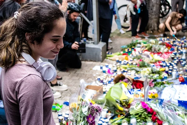 Tel Aviv, İsrail - 8 Nisan 2022 Dizengoff Caddesi 'ndeki Ilka Bar' a düzenlenen terörist saldırının ardından insanlar saldırının gerçekleştiği yere mum ve çiçek bırakmak için geliyorlar.