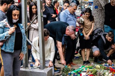 Tel Aviv, İsrail - 8 Nisan 2022 Dizengoff Caddesi 'ndeki Ilka Bar' a düzenlenen terörist saldırının ardından insanlar saldırının gerçekleştiği yere mum ve çiçek bırakmak için geliyorlar.
