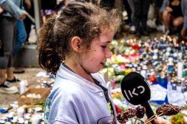 Tel Aviv, İsrail - 8 Nisan 2022 Dizengoff Caddesi 'ndeki Ilka Bar' a düzenlenen terörist saldırının ardından insanlar saldırının gerçekleştiği yere mum ve çiçek bırakmak için geliyorlar.