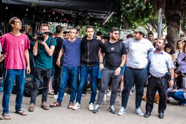 Tel Aviv, İsrail - 8 Nisan 2022 Dizengoff Caddesi 'ndeki Ilka Bar' a yapılan terörist saldırının ardından, genç İsrailli gençler saldırının gerçekleştiği yerde şarkı söylüyorlar.