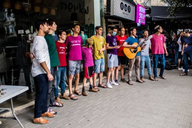 Tel Aviv, İsrail - 8 Nisan 2022 Dizengoff Caddesi 'ndeki Ilka Bar' a yapılan terörist saldırının ardından, genç İsrailli gençler saldırının gerçekleştiği yerde şarkı söylüyorlar.