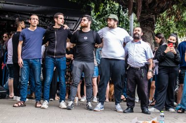 Tel Aviv, İsrail - 8 Nisan 2022 Dizengoff Caddesi 'ndeki Ilka Bar' a yapılan terörist saldırının ardından, genç İsrailli gençler saldırının gerçekleştiği yerde şarkı söylüyorlar.