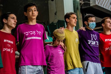 Tel Aviv, İsrail - 8 Nisan 2022 Dizengoff Caddesi 'ndeki Ilka Bar' a yapılan terörist saldırının ardından, genç İsrailli gençler saldırının gerçekleştiği yerde şarkı söylüyorlar.