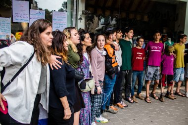 Tel Aviv, İsrail - 8 Nisan 2022 Dizengoff Caddesi 'ndeki Ilka Bar' a yapılan terörist saldırının ardından, genç İsrailli gençler saldırının gerçekleştiği yerde şarkı söylüyorlar.