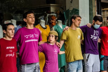 Tel Aviv, İsrail - 8 Nisan 2022 Dizengoff Caddesi 'ndeki Ilka Bar' a yapılan terörist saldırının ardından, genç İsrailli gençler saldırının gerçekleştiği yerde şarkı söylüyorlar.