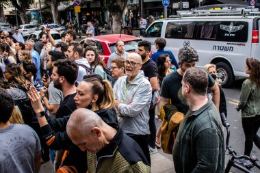 Tel Aviv, İsrail - 8 Nisan 2022 Dizengoff Caddesi 'ndeki Ilka Bar' a yapılan terörist saldırının ardından, genç İsrailli gençler saldırının gerçekleştiği yerde şarkı söylüyorlar.