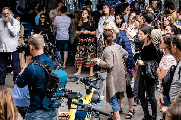 Tel Aviv, İsrail - 8 Nisan 2022 Dizengoff Caddesi 'ndeki Ilka Bar' a yapılan terörist saldırının ardından, genç İsrailli gençler saldırının gerçekleştiği yerde şarkı söylüyorlar.