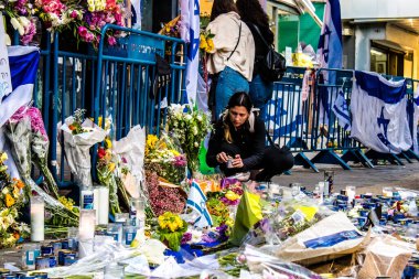 Tel Aviv, İsrail - 10 Nisan 2022 Dizengoff Caddesi 'ndeki Ilka Bar' a düzenlenen terörist saldırının ardından insanlar saldırının gerçekleştiği yere mum ve çiçek bırakmak için geliyorlar.