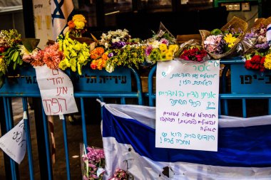 Tel Aviv, İsrail - 10 Nisan 2022 Dizengoff Caddesi 'ndeki Ilka Bar' a düzenlenen terörist saldırının ardından insanlar saldırının gerçekleştiği yere mum ve çiçek bırakmak için geliyorlar.