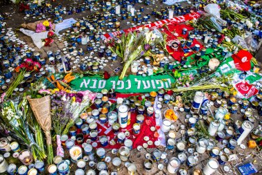 Tel Aviv, İsrail - 10 Nisan 2022 Dizengoff Caddesi 'ndeki Ilka Bar' a düzenlenen terörist saldırının ardından insanlar saldırının gerçekleştiği yere mum ve çiçek bırakmak için geliyorlar.