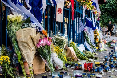 Tel Aviv, İsrail - 10 Nisan 2022 Dizengoff Caddesi 'ndeki Ilka Bar' a düzenlenen terörist saldırının ardından insanlar saldırının gerçekleştiği yere mum ve çiçek bırakmak için geliyorlar.