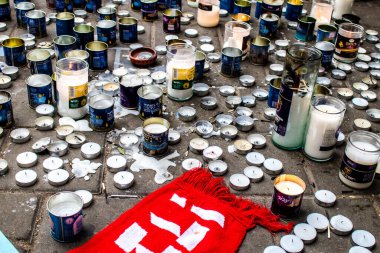 Tel Aviv, İsrail - 10 Nisan 2022 Dizengoff Caddesi 'ndeki Ilka Bar' a düzenlenen terörist saldırının ardından insanlar saldırının gerçekleştiği yere mum ve çiçek bırakmak için geliyorlar.