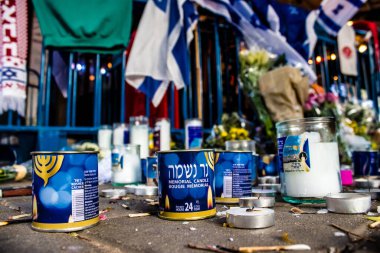 Tel Aviv, İsrail - 10 Nisan 2022 Dizengoff Caddesi 'ndeki Ilka Bar' a düzenlenen terörist saldırının ardından insanlar saldırının gerçekleştiği yere mum ve çiçek bırakmak için geliyorlar.