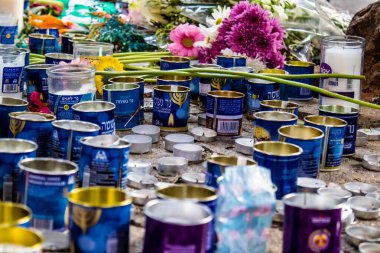 Tel Aviv, İsrail - 10 Nisan 2022 Dizengoff Caddesi 'ndeki Ilka Bar' a düzenlenen terörist saldırının ardından insanlar saldırının gerçekleştiği yere mum ve çiçek bırakmak için geliyorlar.