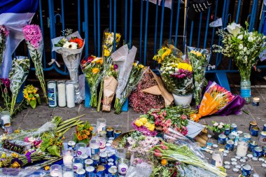 Tel Aviv, İsrail - 10 Nisan 2022 Dizengoff Caddesi 'ndeki Ilka Bar' a düzenlenen terörist saldırının ardından insanlar saldırının gerçekleştiği yere mum ve çiçek bırakmak için geliyorlar.