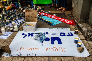 Tel Aviv, İsrail - 10 Nisan 2022 Dizengoff Caddesi 'ndeki Ilka Bar' a düzenlenen terörist saldırının ardından insanlar saldırının gerçekleştiği yere mum ve çiçek bırakmak için geliyorlar.
